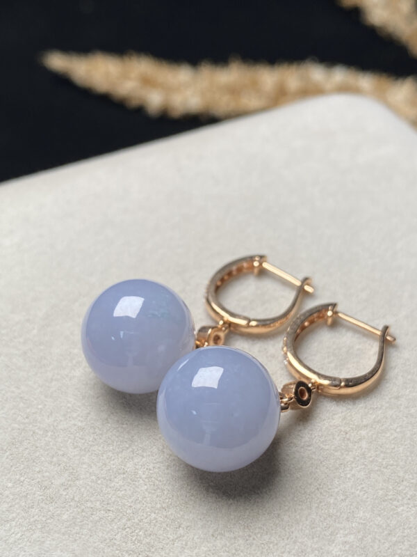Front view of 18K ice purple jade earrings showcasing smooth translucent purple jade beads