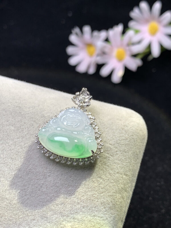 Close-up detail of carved icy green Buddha on jadeite pendant with 18K gold frame