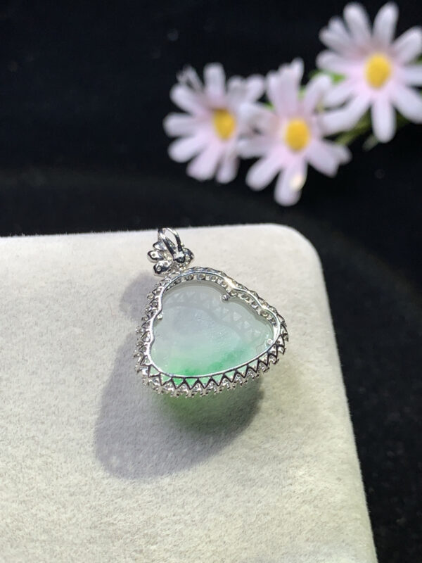 Back view of carved jadeite pendant showing smooth jade surface and gold clasp