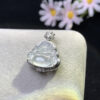 Side profile of 18K gold pendant with white jade Buddha showing depth and thickness