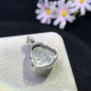 Side profile of 18K gold pendant with white jade Buddha showing depth and thickness