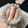 Close-up of yellow, purple, and green jade beads on beaded bracelet