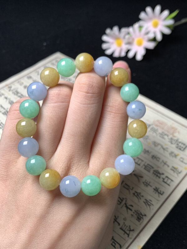 Close-up of yellow, purple, and green jade beads on beaded bracelet