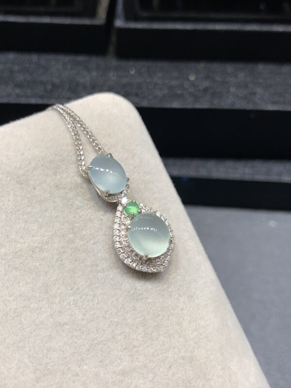 Model wearing 18K gold jade necklaces with ice-clear oval pendants