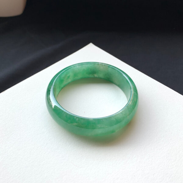 Side angle of full-green icy green jade bracelets showing thickness and texture