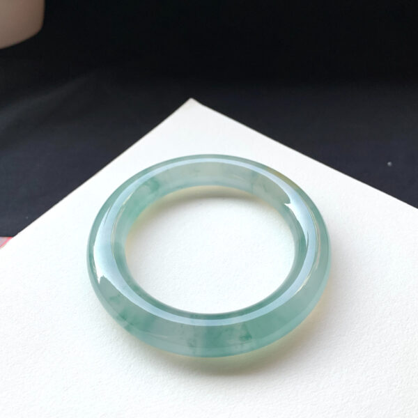 Side angle showing the bangle’s green swirls and glossy surface