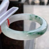 Close-up of floating floral inclusions inside old icy jadeite bangle