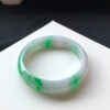 Close-up texture of genuine jade bracelets showing bright green icy jade detail