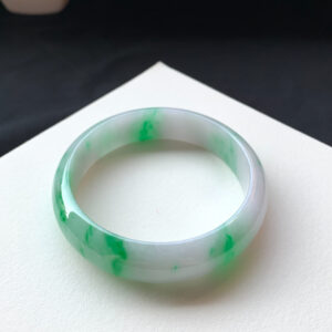 Close-up texture of genuine jade bracelets showing bright green icy jade detail