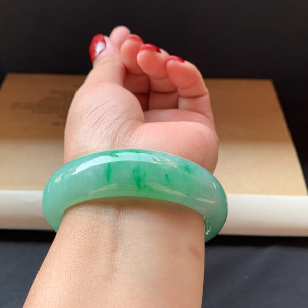 Woman wearing jade bracelets on wrist in natural light