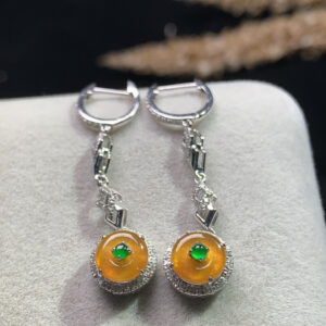 Front view of 18K gold orange-yellow jade dangling earrings with smooth circular peace buckle design