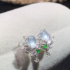 Close-up front view of 18K white ice jade diamond earrings with oval cabochon design