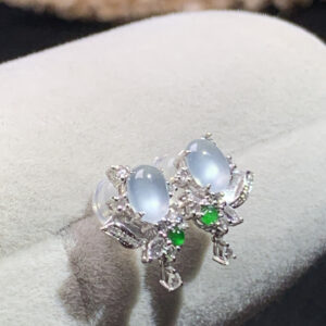 Close-up front view of 18K white ice jade diamond earrings with oval cabochon design