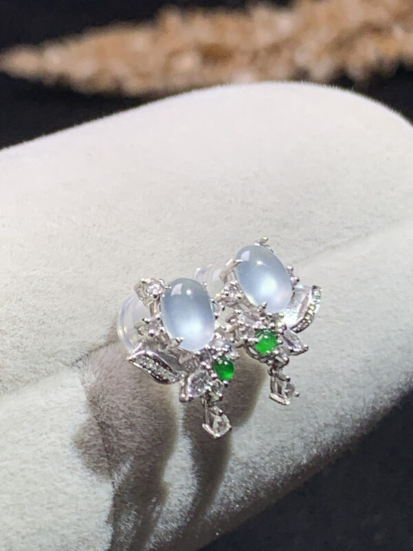 Close-up front view of 18K white ice jade diamond earrings with oval cabochon design