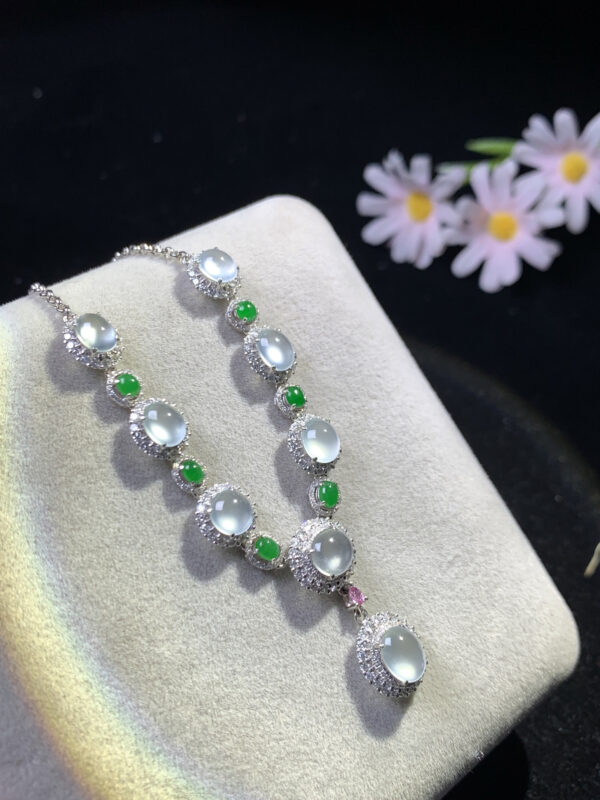 Front view of 18K gold jade necklace featuring white icy and full green jade cabochon pendants