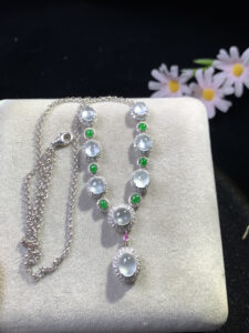 Luxurious jade necklace with 8 white icy jade cabochons, 6 full green jade cabochons, and 1 small violet jade cabochon, each surrounded by small diamonds set in 18K gold.