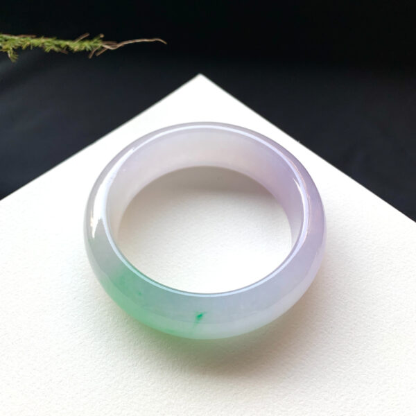Translucent jade stone bracelet with spring green hues, conveying vitality and good fortune.