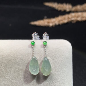 Close-up front view of 18K gold jade teardrop earrings with delicate magnolia flower design