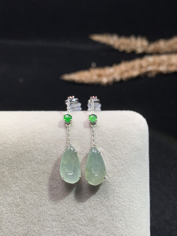 Close-up front view of 18K gold jade teardrop earrings with delicate magnolia flower design