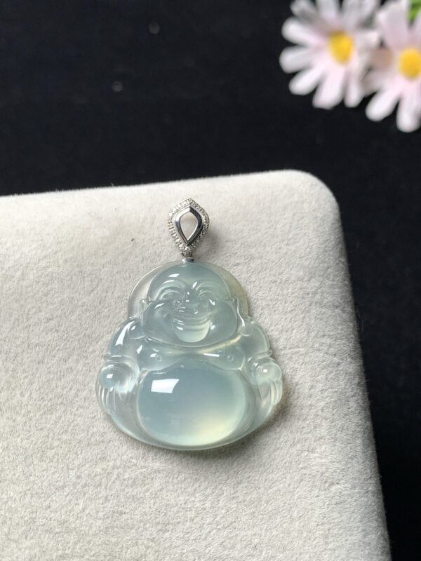 Close-up detail of Buddha carving on icy jadeite pendant with 18K gold border