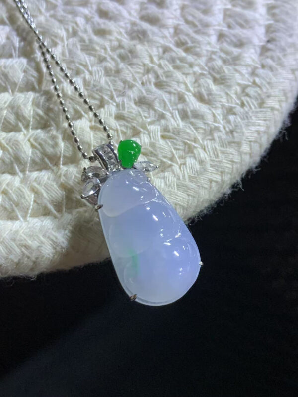 Front view of 18K gold lavender jade pendant featuring icy purple and floating green lucky bean carving