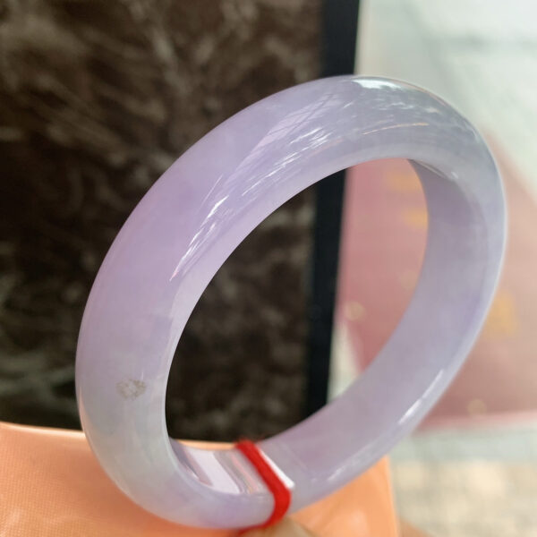 Purple jade bracelet worn on wrist highlighting smooth round shape and vibrant color