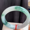 Real jade bangle bracelet front view with icy translucence and floating floral patterns