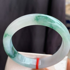 Real jade bangle bracelet front view with icy translucence and floating floral patterns