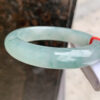 Side view of 56mm real jade bangle showing thickness and smooth polish