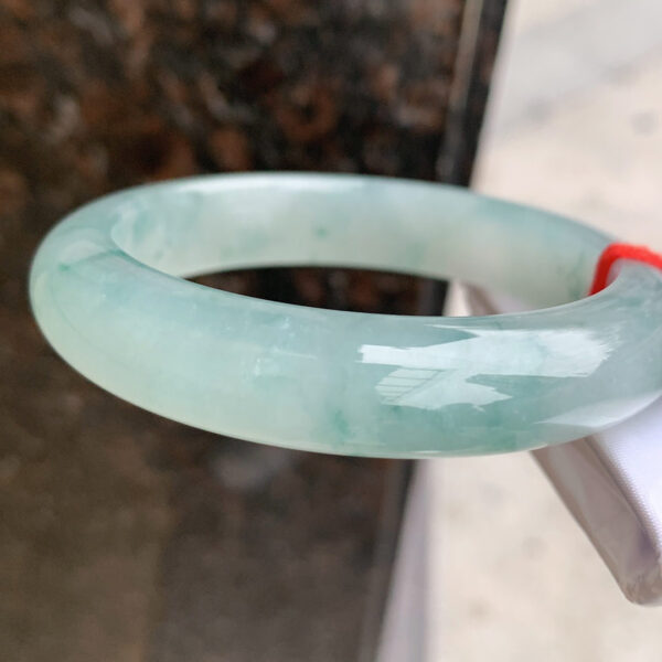 Side view of 56mm real jade bangle showing thickness and smooth polish