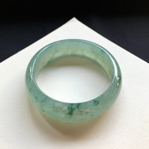 Front view of wide real jade bracelet with icy green patterns