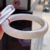 Side profile of chunky red jade bangle showing thickness and round shape