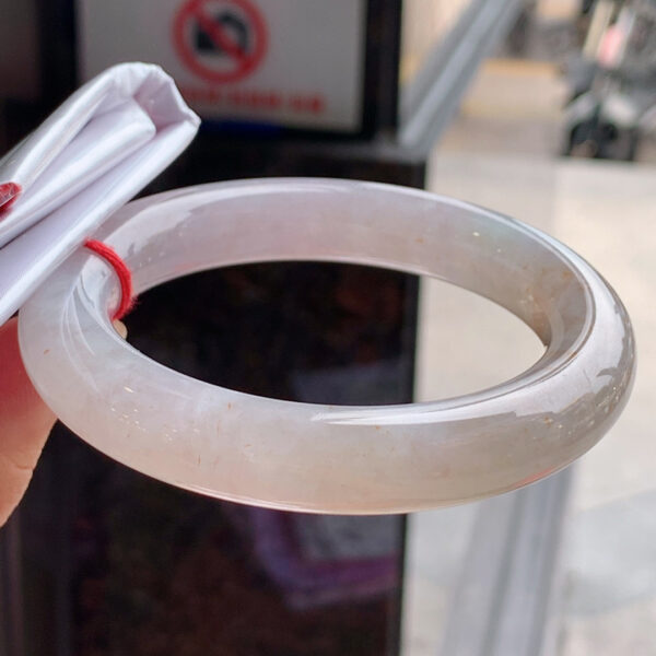 Side profile of chunky red jade bangle showing thickness and round shape