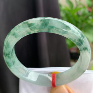 Vintage jade bracelet front view with icy translucence and floating floral patterns
