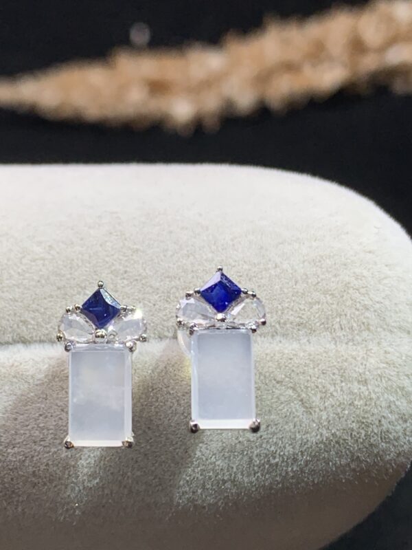 Front view of 18K white ice jade huggie earrings showcasing smooth white jade and polished gold setting