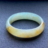 Yellow jade princess bangle with natural floral patterns, front view