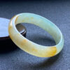 Right side view of yellow jade princess bangle with natural patterns