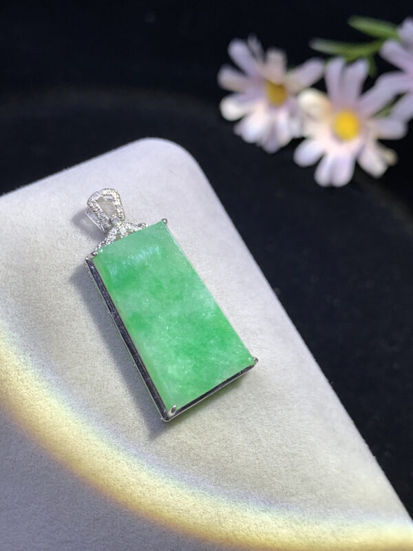 Close-up of 18K fruit green Wu Shi jadeite pendant showcasing vibrant natural jade colors and intricate carving