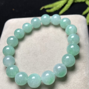 Close-up of jade mens bracelet featuring 11mm light green jadeite beads with smooth polished surface