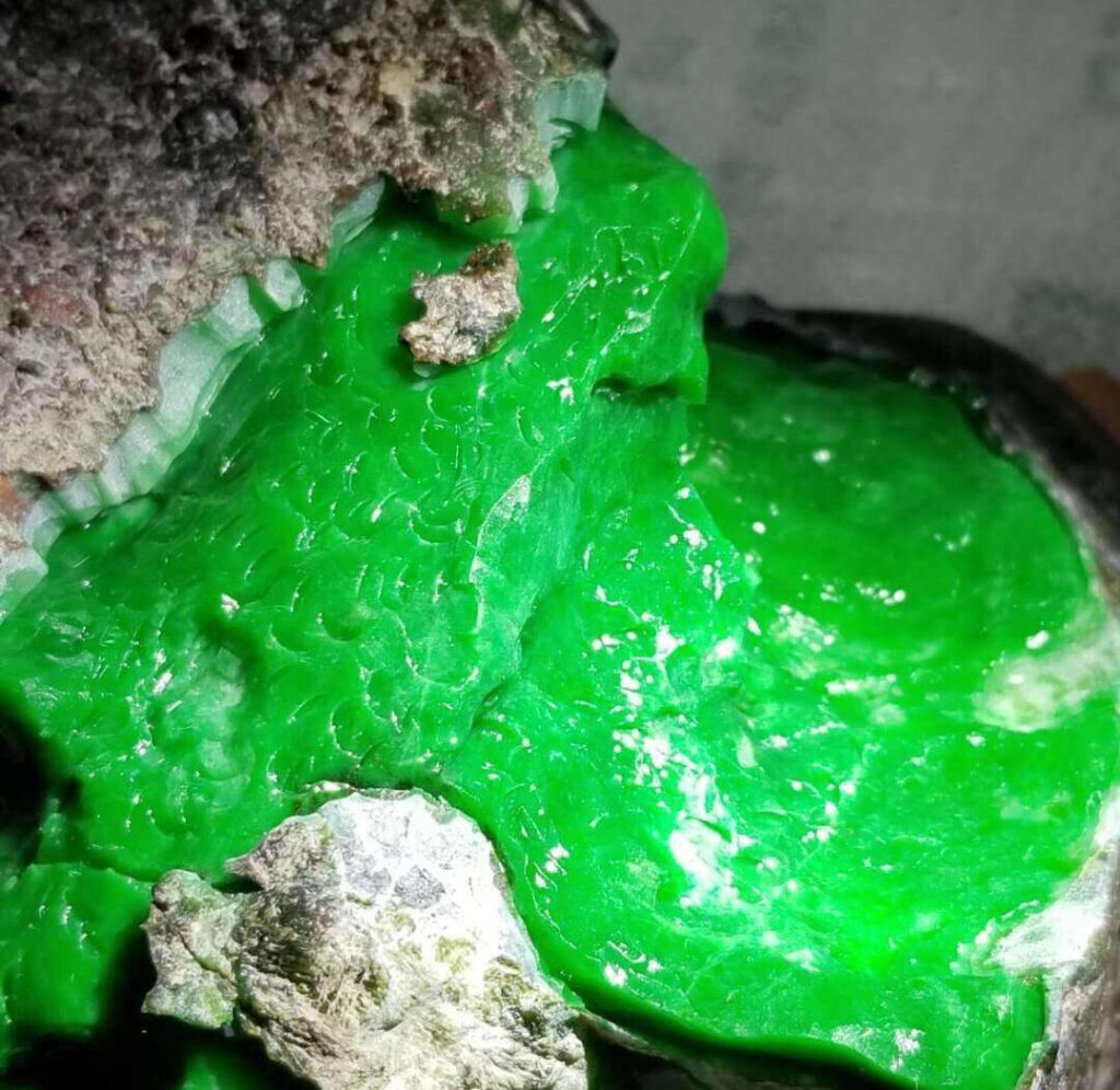 Close-up of a genuine jadeite stone showing its smooth, waxy texture