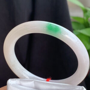 Natural jadeite bangle with white base and vibrant green stripes, oval shape 54.5mm, showcasing fine grain texture and radiant color